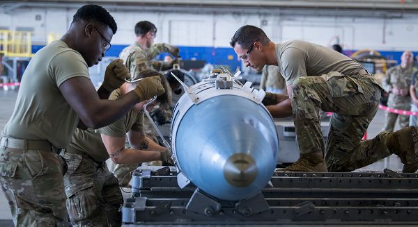 Senior Airman Yvener Desir, Airman 1st Class Andrew Bankson and Staff Sgt. Michael Rosa, all with the 96th Maintenance Squadron, race side-by-side against other ammo teams to build a Joint Direct Attack Munition GBU-31 prior to the 96th Maintenance Group’s weapons load competition Oct. 27, 2023, at Eglin Air Force Base, Fla. Two ammo teams quickly and precisely built the bombs that would be loaded onto an F-15 Eagle and F-16 Fighting Falcon by weapons loaders. (U.S. Air Force photo by Samuel King Jr.) 
