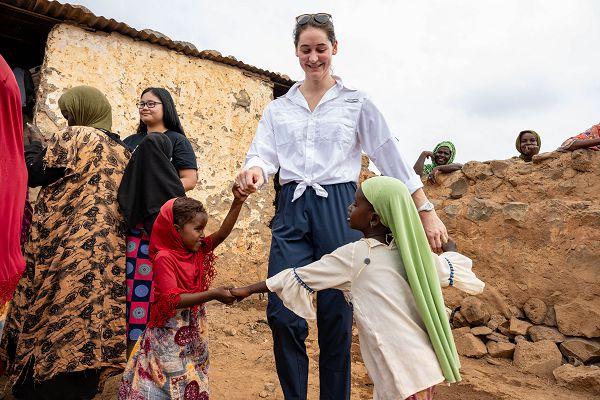 U.S. Air Force Capt. Elise Hart, 449th Air Expeditionary Group chief of information operations, dances with local children during a community engagement in Chabelley Village, Djibouti, Dec. 29, 2023. Volunteers from Combined Joint Task Force-Horn of Africa, out of Camp Lemonnier, visited the village to deliver books and various personal hygiene items, reaffirming the trusted partnership between the U.S. and African partners. (U.S. Air Force photo by Staff Sgt. Allison Payne)