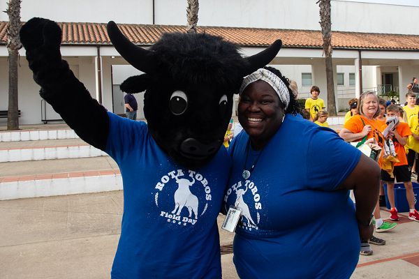 NAVAL STATION ROTA, Spain (May 18, 2023) Third grade teacher Marla Echols, right, poses for a photo with Rota Elementary School's mascot Toro, during the welcome ceremony for field day, May 18, 2023. (U.S. Navy photo by Courtney Pollock)