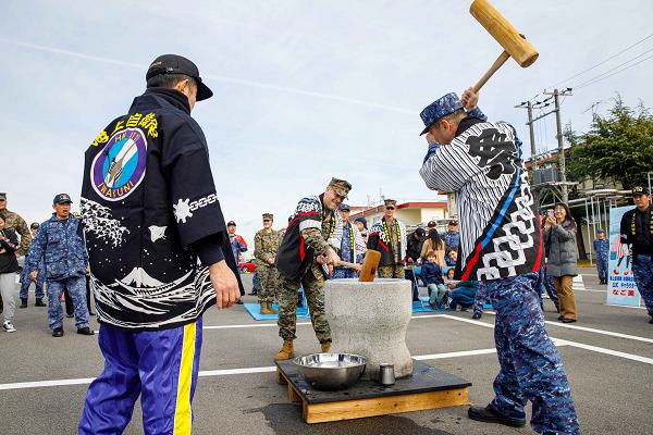 U.S. Marine Corps Col. Richard Rusnok, center, the commanding officer of Marine Corps Air Station Iwakuni, and a native of Pennsylvania, and Japan Maritime Self-Defense Force Rear Adm. Ichiro Ishikawa, right, commander of Fleet Air Wing 31, hammer rice to make mochi together during a traditional Mochitsuki mochi pounding event at Marine Corps Air Station Iwakuni, Japan, Dec. 13, 2024. FAW 31 hosts a traditional Mochitsuki event annually and invites members of the MCAS Iwakuni community to participate and learn more about Japanese New Year’s traditions and culture. (U.S. Marine Corps photo by Lance Cpl. David Getz)