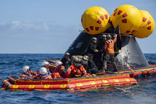Sailors assigned to amphibious transport dock USS Somerset (LPD 25), Explosive Ordnance Disposal Group 1, Helicopter Sea Combat Squadron 23 “Wildcards,” and NASA personnel assist NASA Astronauts onto the “front porch,” an inflatable raft, during NASA Underway Recovery Test 12 in the Pacific Ocean, March 28, 2025. In preparation for NASA's Artemis II crewed mission, which will send four astronauts around the Moon and beyond in the Orion spacecraft, NASA and the Department of Defense will conduct a series of tests to demonstrate and evaluate the processes, procedures, and hardware used in recovery operations for crewed lunar missions. The Department of Defense has many unique capabilities that make it an ideal partner to support NASA, including its amphibious ships with the ability to embark helicopters, launch and recover small boats and provide medical care at advanced onboard facilities. (U.S. Navy photo by Mass Communication Specialist 2nd Class Olivia Rucker)