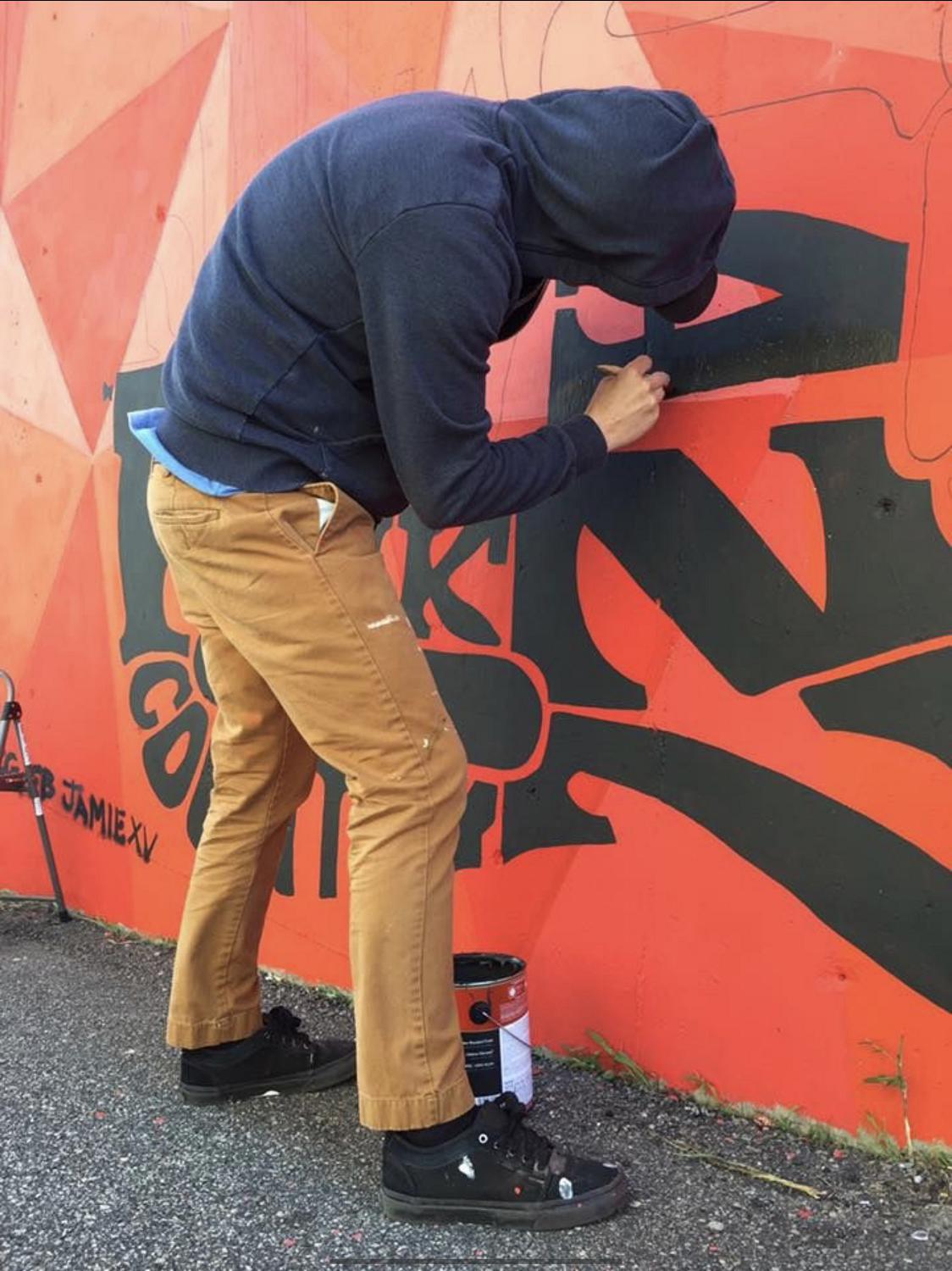 Navy Petty Officer 1st Class Jamie Pearson works on one of his murals.