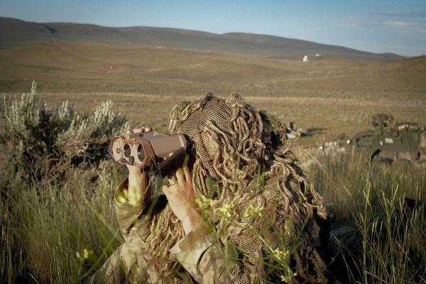 U.S. Army Spc. Mackenzie Jones, a sniper with 3rd Battalion, 161st Infantry Regiment, 81st Stryker Brigade Combat Team, Washington National Guard, identifies and reports targets for a company live fire range at Yakima Training Center, Wash., June 10, 2024. The live fire range is the final mission of annual training, combining skills practiced throughout the year. (U.S. Army National Guard photo by Sgt. Remi Milslagle)