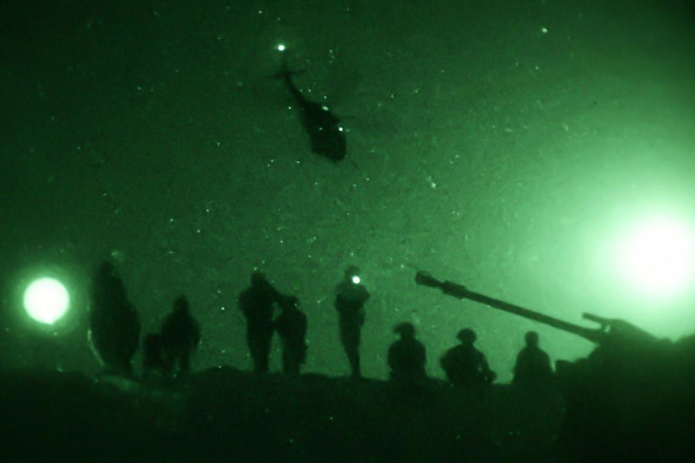 A U.S. Army UH-60 Black Hawk helicopter flies over U.S. Soldiers of the 1st Battalion, 5th Infantry Regiment, 1st Brigade Combat Team, 25th Infantry Division, at Al Asad Air Base, Iraq, May 29, 2020. Live fire exercises performed at night prepare Soldiers to operate in any lighting conditions. (U.S. Army photo by Spc. Derek Mustard)
